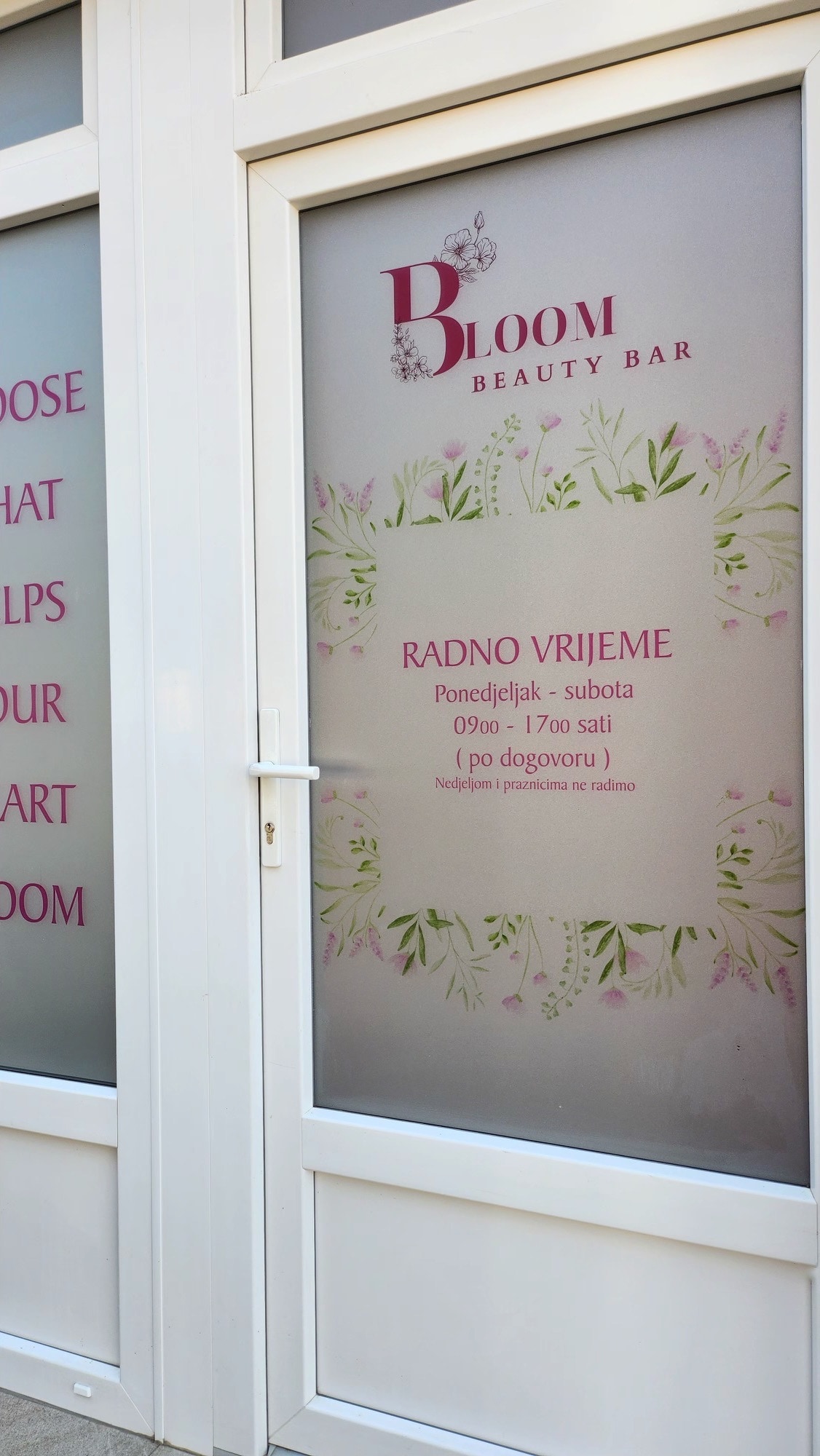 Ulazna vrata salona s logom Bloom i radnim vremenom